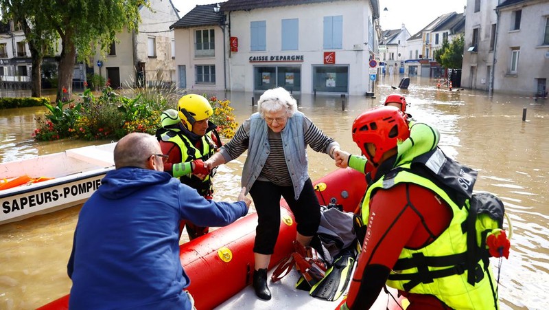 Petugas pemadam kebakaran Prancis berjalan dengan perahu di jalan yang banjir untuk mengevakuasi penduduk di Crecy-la-Chapelle, departemen Seine-et-Marne, setelah hujan lebat dan badai Kirk menyebabkan banjir di negara itu, Prancis, 11 Oktober 2024. (REUTERS/Abdul Saboor)