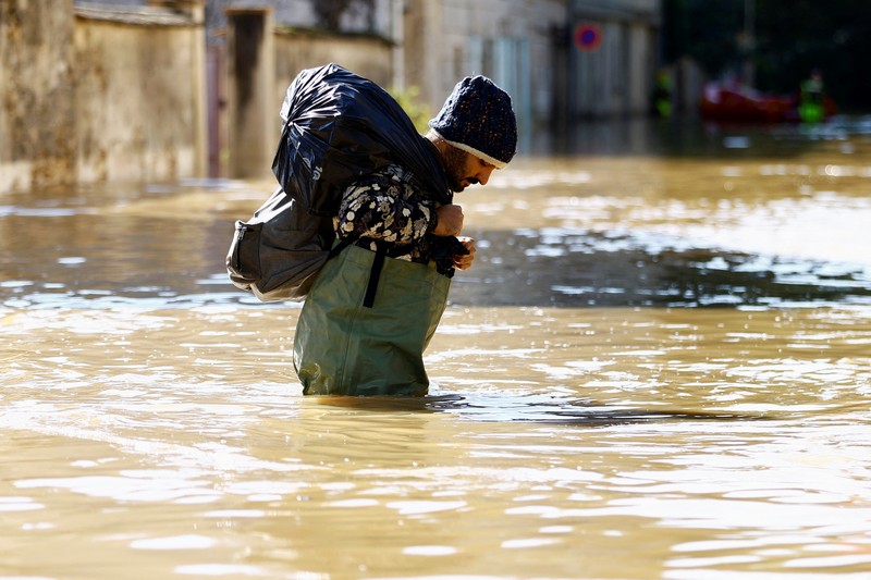 Petugas pemadam kebakaran Prancis berjalan dengan perahu di jalan yang banjir untuk mengevakuasi penduduk di Crecy-la-Chapelle, departemen Seine-et-Marne, setelah hujan lebat dan badai Kirk menyebabkan banjir di negara itu, Prancis, 11 Oktober 2024. (REUTERS/Abdul Saboor)