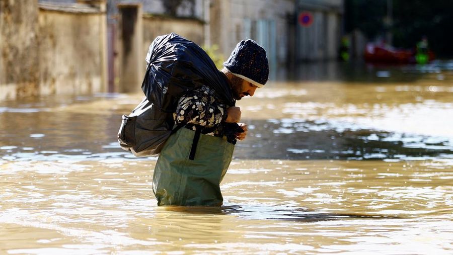 Petugas pemadam kebakaran Prancis berjalan dengan perahu di jalan yang banjir untuk mengevakuasi penduduk di Crecy-la-Chapelle, departemen Seine-et-Marne, setelah hujan lebat dan badai Kirk menyebabkan banjir di negara itu, Prancis, 11 Oktober 2024. (REUTERS/Abdul Saboor)
