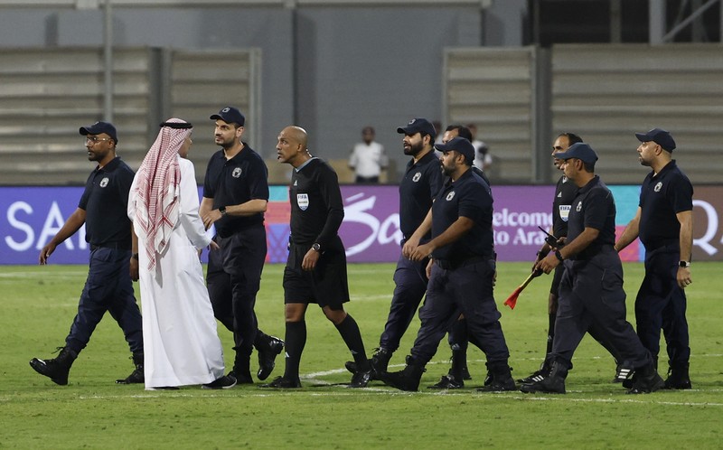 SOCCER-WORLDCUP-BHR-IDN/REPORT Soccer Football - World Cup - Asian Qualifiers - Third Round - Group C - Bahrain v Indonesia - Bahrain National Stadium, Riffa, Bahrain - October 10, 2024 Referee Ahmed Al-Kaf with police after the match REUTERS/Hamad I Mohammed