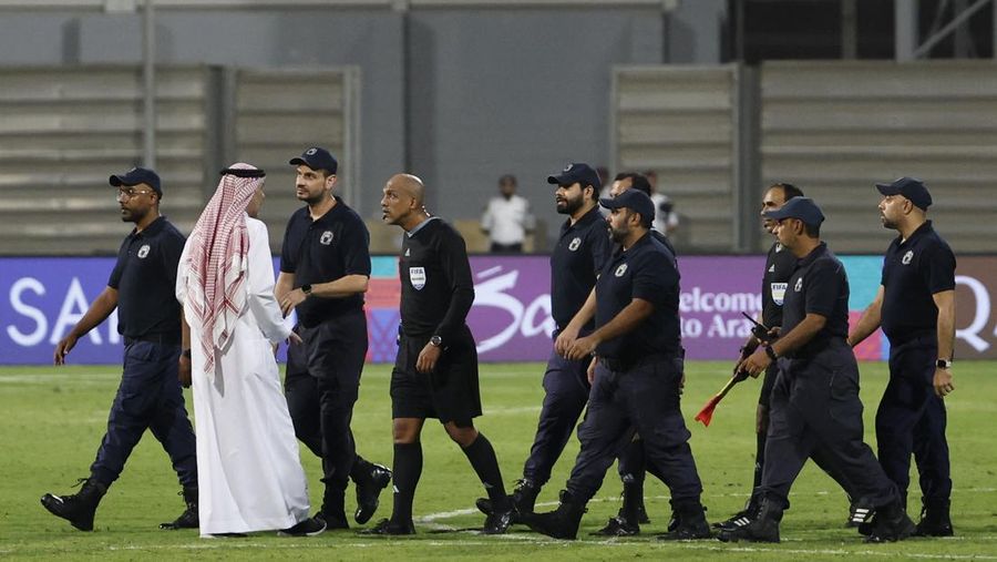 Wasit Ahmed Al-Kaf dikawal polisi setelah pertandingan Putaran Ketiga , babak kualifikasi Piala Dunia Bahrain vs Indonesia di Stadion Nasional Bahrain, Riffa, Kamis, 10/10. REUTERS/Hamad I Mohammed