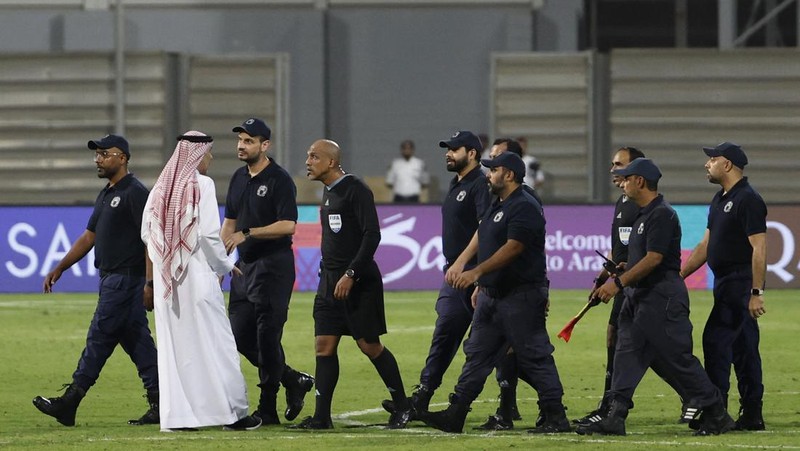 Soccer Football - World Cup - Asian Qualifiers - Third Round - Group C - Bahrain v Indonesia - Bahrain National Stadium, Riffa, Bahrain - October 10, 2024 Referee Ahmed Al-Kaf with police after the match REUTERS/Hamad I Mohammed