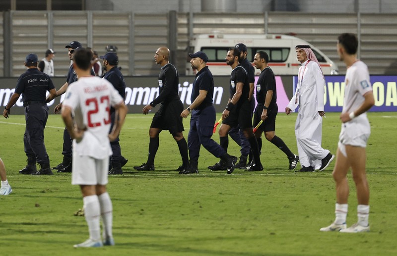 SOCCER-WORLDCUP-BHR-IDN/REPORT Soccer Football - World Cup - Asian Qualifiers - Third Round - Group C - Bahrain v Indonesia - Bahrain National Stadium, Riffa, Bahrain - October 10, 2024 Referee Ahmed Al-Kaf with police after the match REUTERS/Hamad I Mohammed
