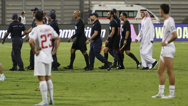 Soccer Football - World Cup - Asian Qualifiers - Third Round - Group C - Bahrain v Indonesia - Bahrain National Stadium, Riffa, Bahrain - October 10, 2024 Referee Ahmed Al-Kaf with police after the match REUTERS/Hamad I Mohammed