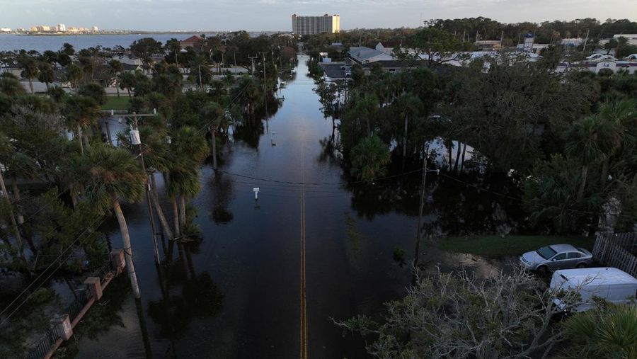 Pemandangan drone menunjukkan sebuah mobil melaju melalui jalan yang banjir setelah Badai Milton menerjang daratan di South Daytona, Florida, Amerika Serikat, Jumat (11/10/2024). (REUTERS/Ricardo Arduengo)