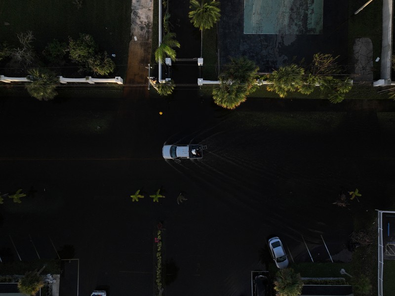 Pemandangan drone menunjukkan sebuah mobil melaju melalui jalan yang banjir setelah Badai Milton menerjang daratan di South Daytona, Florida, Amerika Serikat, Jumat (11/10/2024). (REUTERS/Ricardo Arduengo)