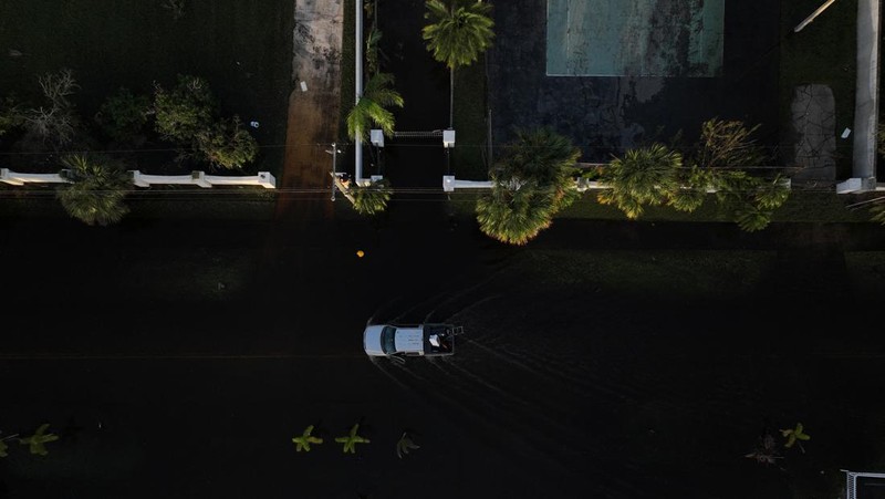 Pemandangan drone menunjukkan sebuah mobil melaju melalui jalan yang banjir setelah Badai Milton menerjang daratan di South Daytona, Florida, Amerika Serikat, Jumat (11/10/2024). (REUTERS/Ricardo Arduengo)