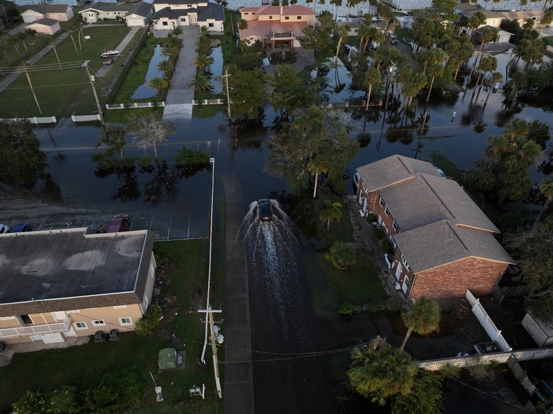 Pemandangan drone menunjukkan sebuah mobil melaju melalui jalan yang banjir setelah Badai Milton menerjang daratan di South Daytona, Florida, Amerika Serikat, Jumat (11/10/2024). (REUTERS/Ricardo Arduengo)