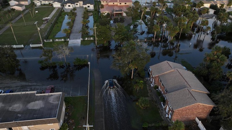 Pemandangan drone menunjukkan sebuah mobil melaju melalui jalan yang banjir setelah Badai Milton menerjang daratan di South Daytona, Florida, Amerika Serikat, Jumat (11/10/2024). (REUTERS/Ricardo Arduengo)