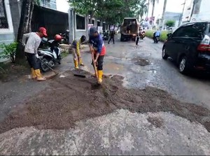 Jalan Opi Raya Palembang yang Rusak-Berlubang Ditambal dengan Pasir-Diaspal