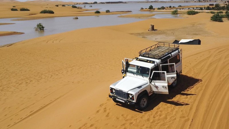Sebuah Oasis tercermin di sebuah danau yang disebabkan oleh hujan lebat di kota gurun Merzouga, dekat Rachidia, tenggara Maroko, Rabu, 2 Oktober 2024. (AP Photo)