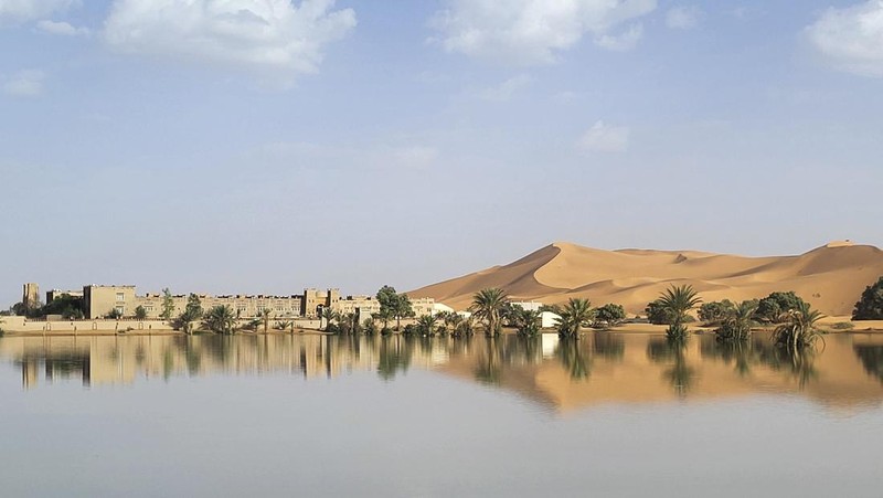 Sebuah Oasis tercermin di sebuah danau yang disebabkan oleh hujan lebat di kota gurun Merzouga, dekat Rachidia, tenggara Maroko, Rabu, 2 Oktober 2024. (AP Photo)