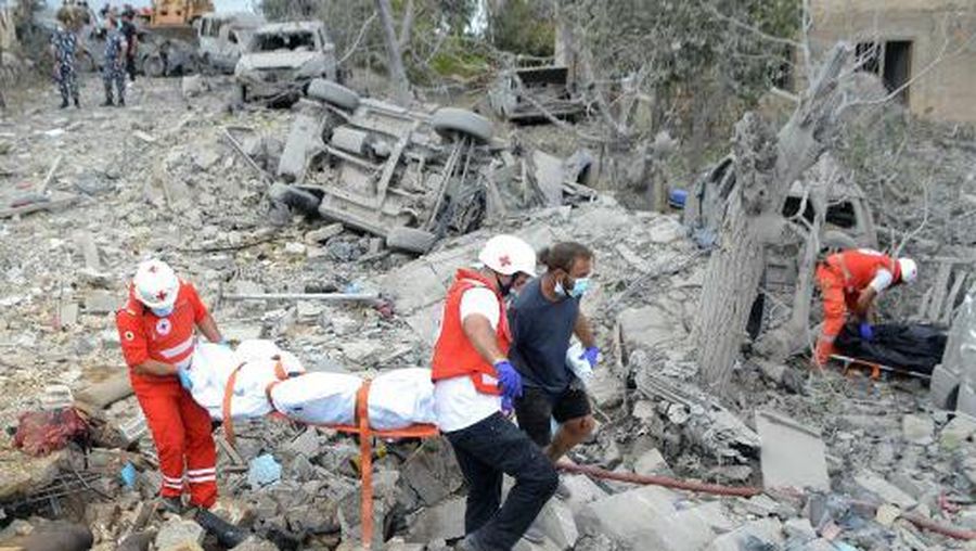 Paramedics with the Lebanese Red Cross transport a body unearthed from the rubble at the site of an Israeli airstrike that targeted the northern Lebanese village of Aito on October 14, 2024. The Lebanese Red Cross said at least 18 people died in a strike on north Lebanon on October 14, with the health ministry and official media reporting an Israeli raid on the Christian-majority area far from Hezbollah strongholds. (Photo by Fathi AL-MASRI / AFP)