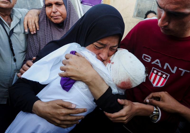 Warga Palestina memeriksa kerusakan di lokasi serangan Israel terhadap tenda-tenda yang menampung orang-orang terlantar, di tengah konflik Israel-Hamas, di rumah sakit Martir Al-Aqsa di Deir Al-Balah di Jalur Gaza tengah, 14 Oktober 2024. (REUTERS/Ramadan Abed)