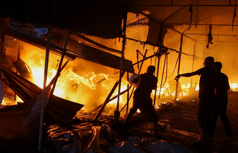 Warga Palestina memeriksa kerusakan di lokasi serangan Israel terhadap tenda-tenda yang menampung orang-orang terlantar, di tengah konflik Israel-Hamas, di rumah sakit Martir Al-Aqsa di Deir Al-Balah di Jalur Gaza tengah, 14 Oktober 2024. (REUTERS/Ramadan Abed)