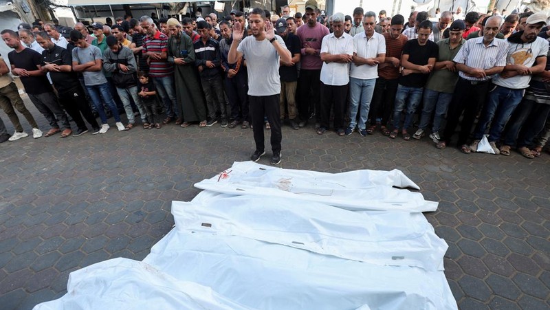 Warga Palestina memeriksa kerusakan di lokasi serangan Israel terhadap tenda-tenda yang menampung orang-orang terlantar, di tengah konflik Israel-Hamas, di rumah sakit Martir Al-Aqsa di Deir Al-Balah di Jalur Gaza tengah, 14 Oktober 2024. (REUTERS/Ramadan Abed)