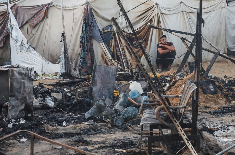 Warga Palestina memeriksa kerusakan di lokasi serangan Israel terhadap tenda-tenda yang menampung orang-orang terlantar, di tengah konflik Israel-Hamas, di rumah sakit Martir Al-Aqsa di Deir Al-Balah di Jalur Gaza tengah, 14 Oktober 2024. (REUTERS/Ramadan Abed)