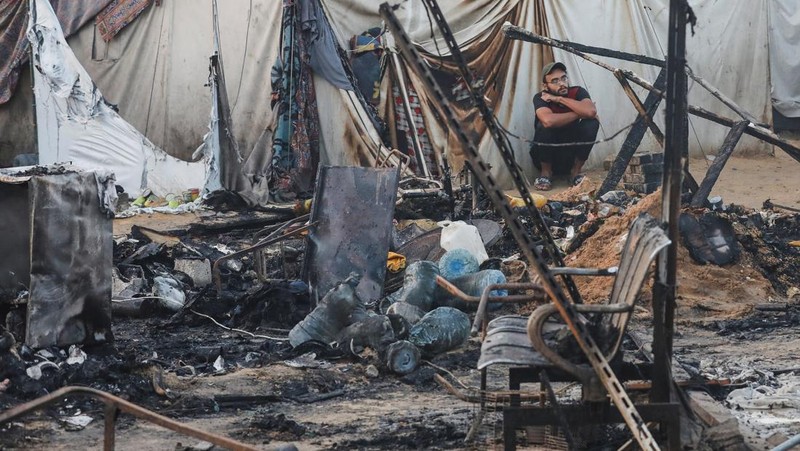 Warga Palestina memeriksa kerusakan di lokasi serangan Israel terhadap tenda-tenda yang menampung orang-orang terlantar, di tengah konflik Israel-Hamas, di rumah sakit Martir Al-Aqsa di Deir Al-Balah di Jalur Gaza tengah, 14 Oktober 2024. (REUTERS/Ramadan Abed)