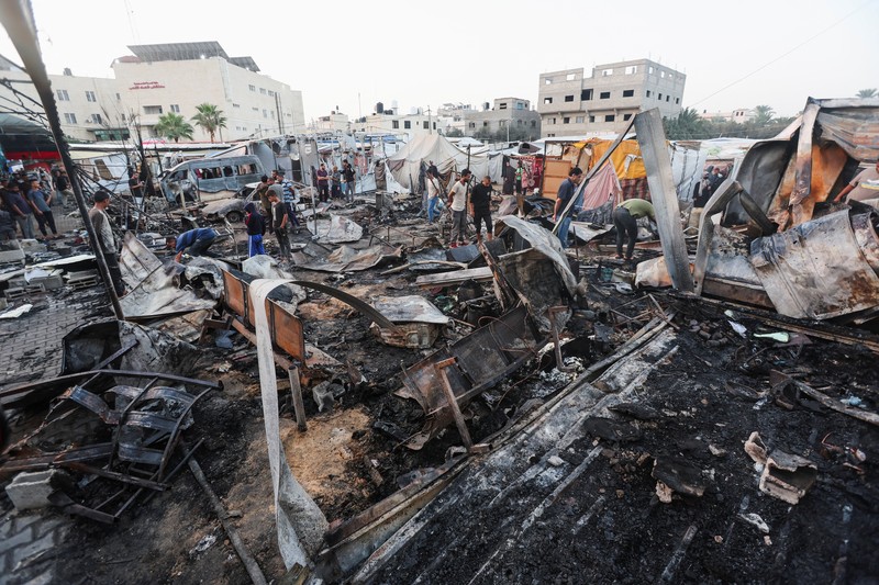 Warga Palestina memeriksa kerusakan di lokasi serangan Israel terhadap tenda-tenda yang menampung orang-orang terlantar, di tengah konflik Israel-Hamas, di rumah sakit Martir Al-Aqsa di Deir Al-Balah di Jalur Gaza tengah, 14 Oktober 2024. (REUTERS/Ramadan Abed)