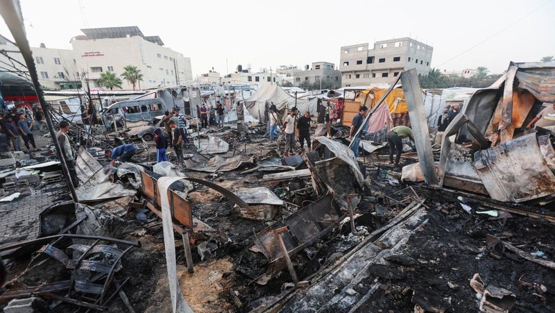 Warga Palestina memeriksa kerusakan di lokasi serangan Israel terhadap tenda-tenda yang menampung orang-orang terlantar, di tengah konflik Israel-Hamas, di rumah sakit Martir Al-Aqsa di Deir Al-Balah di Jalur Gaza tengah, 14 Oktober 2024. (REUTERS/Ramadan Abed)