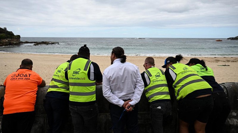 Kemunculan ratusan bola hitam misterius, yang menyerupai ter atau aspal, telah membuat dua pantai populer di area Sydney, Australia, ditutup sementara. (Saeed KHAN / AFP)