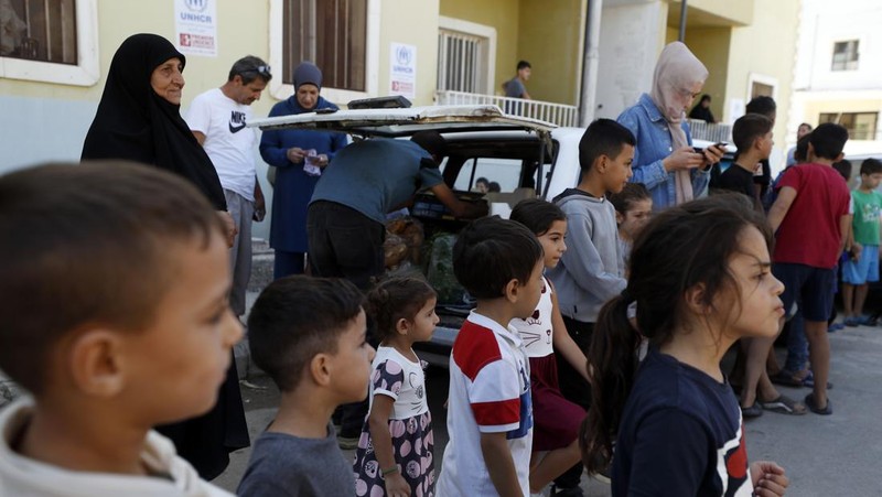 Orang-orang berjalan di tempat penampungan yang menampung orang-orang terlantar yang melarikan diri dari Lebanon ke Suriah karena permusuhan yang sedang berlangsung antara Hizbullah dan pasukan Israel, di Herjelleh, Suriah, 15 Oktober 2024. (REUTERS/Firas Makdesi)