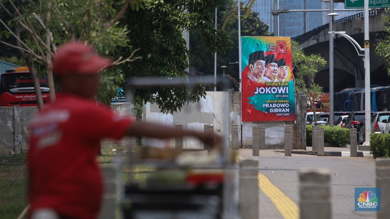 Warga berjalan di dekat spanduk bertuliskan 'Selamat Bekerja Prabowo-Gibran' di Jakarta, Kamis (17/10/2024). (CNBC Indonesia/Faisal Rahman)