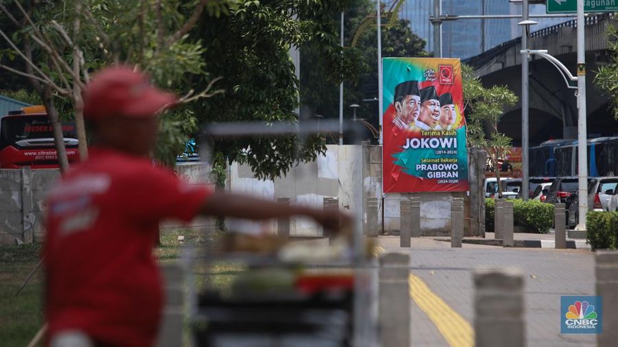 Warga berjalan di dekat spanduk bertuliskan 'Selamat Bekerja Prabowo-Gibran' di Jakarta, Kamis (17/10/2024). (CNBC Indonesia/Faisal Rahman)