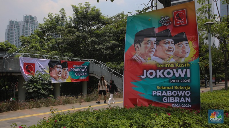 Warga berjalan di dekat spanduk bertuliskan 'Selamat Bekerja Prabowo-Gibran' di Jakarta, Kamis (17/10/2024). (CNBC Indonesia/Faisal Rahman)