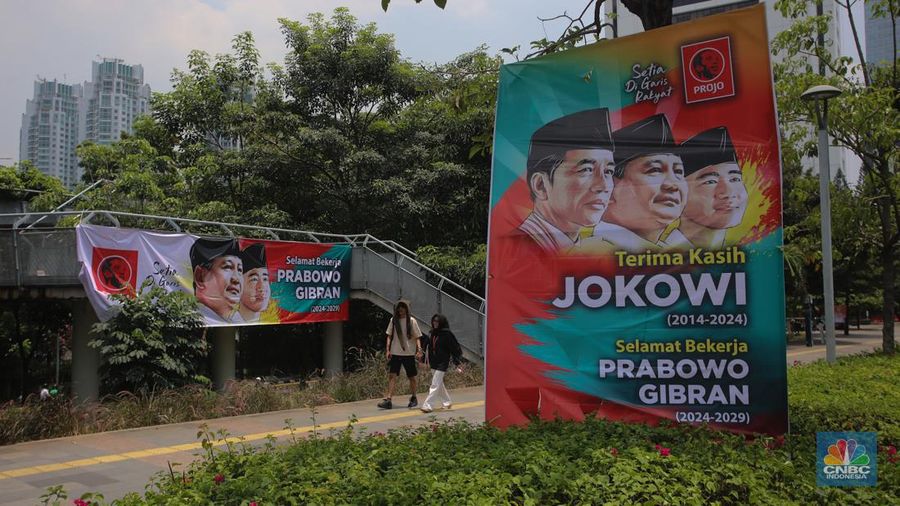 Warga berjalan di dekat spanduk bertuliskan 'Selamat Bekerja Prabowo-Gibran' di Jakarta, Kamis (17/10/2024). (CNBC Indonesia/Faisal Rahman)