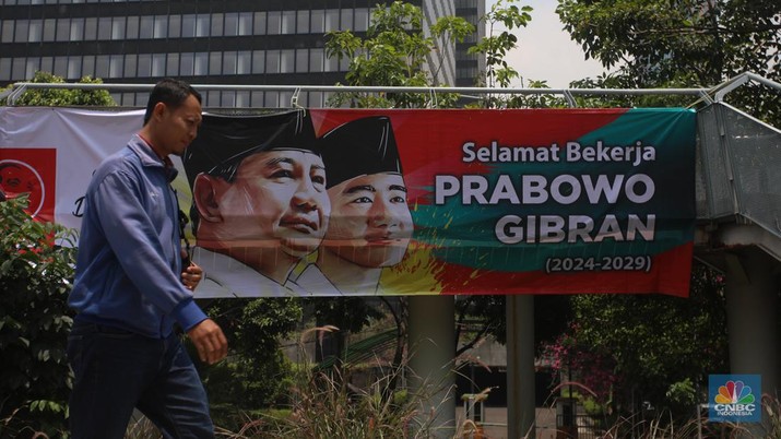 Warga berjalan di dekat spanduk bertuliskan 'Selamat Bekerja Prabowo-Gibran' di Jakarta, Kamis (17/10/2024). (CNBC Indonesia/Faisal Rahman)