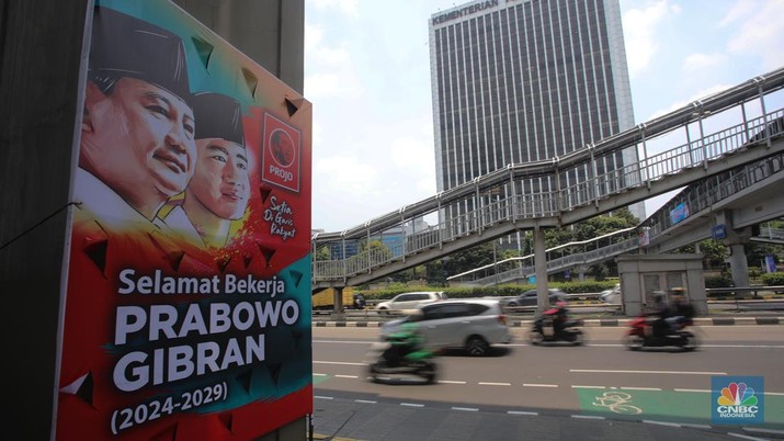Warga berjalan di dekat spanduk bertuliskan 'Selamat Bekerja Prabowo-Gibran' di Jakarta, Kamis (17/10/2024). (CNBC Indonesia/Faisal Rahman)