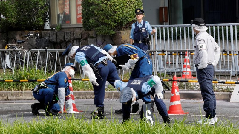 Polisi membawa alat pemadam kebakaran di dekat lokasi mobil tersangkut di pagar, dekat pintu masuk kantor Perdana Menteri di Tokyo, Jepang, Sabtu (19/10). Setelah seorang Pria (40) ditangkap di Tokyo setelah melemparkan bom molotov ke markas partai berkuasa. Peristiwa ini terjadi menjelang pemilihan umum. (REUTERS/Kim Kyung-Hoon)