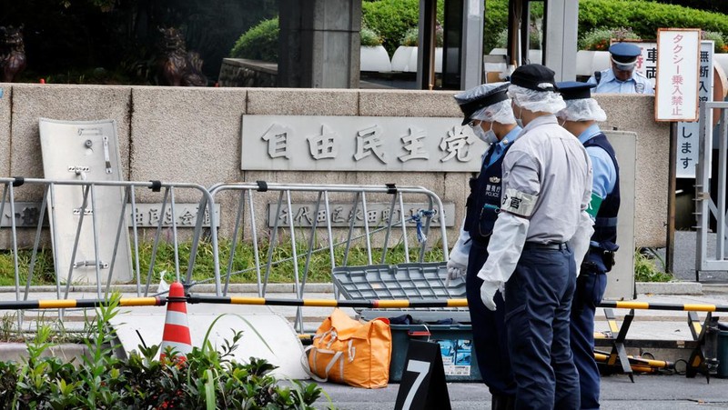 Polisi membawa alat pemadam kebakaran di dekat lokasi mobil tersangkut di pagar, dekat pintu masuk kantor Perdana Menteri di Tokyo, Jepang, Sabtu (19/10). Setelah seorang Pria (40) ditangkap di Tokyo setelah melemparkan bom molotov ke markas partai berkuasa. Peristiwa ini terjadi menjelang pemilihan umum. (REUTERS/Kim Kyung-Hoon)