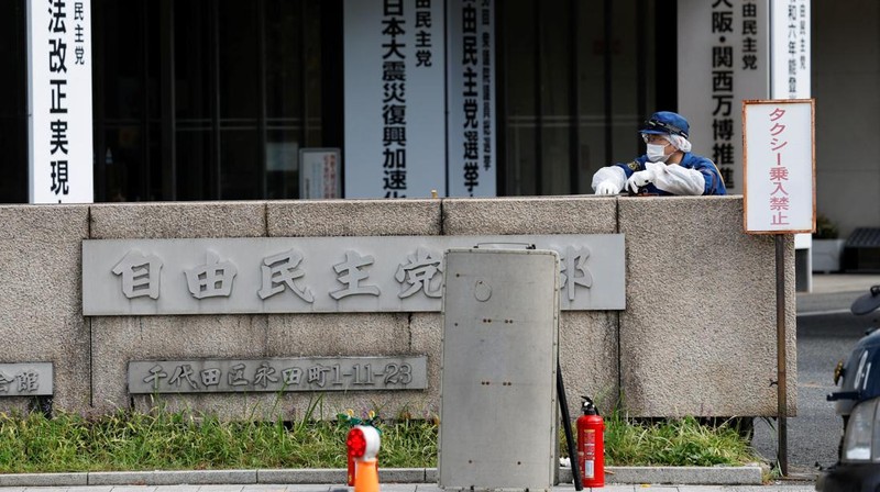 Polisi membawa alat pemadam kebakaran di dekat lokasi mobil tersangkut di pagar, dekat pintu masuk kantor Perdana Menteri di Tokyo, Jepang, Sabtu (19/10). Setelah seorang Pria (40) ditangkap di Tokyo setelah melemparkan bom molotov ke markas partai berkuasa. Peristiwa ini terjadi menjelang pemilihan umum. (REUTERS/Kim Kyung-Hoon)