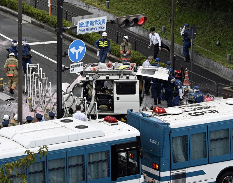 Polisi membawa alat pemadam kebakaran di dekat lokasi mobil tersangkut di pagar, dekat pintu masuk kantor Perdana Menteri di Tokyo, Jepang, Sabtu (19/10). Setelah seorang Pria (40) ditangkap di Tokyo setelah melemparkan bom molotov ke markas partai berkuasa. Peristiwa ini terjadi menjelang pemilihan umum. (REUTERS/Kim Kyung-Hoon) Polisi membawa alat pemadam kebakaran di dekat lokasi mobil tersangkut di pagar, dekat pintu masuk kantor Perdana Menteri di Tokyo, Jepang, Sabtu (19/10). Setelah seorang Pria (40) ditangkap di Tokyo setelah melemparkan bom molotov ke markas partai berkuasa. Peristiwa ini terjadi menjelang pemilihan umum. (REUTERS/Kim Kyung-Hoon)