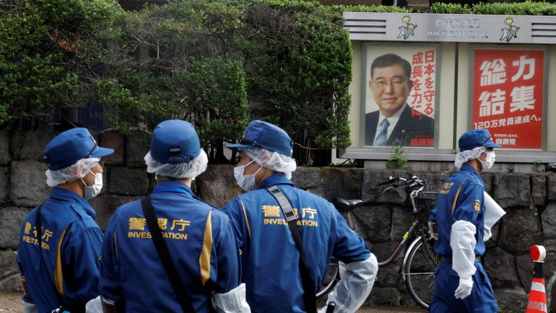 Polisi membawa alat pemadam kebakaran di dekat lokasi mobil tersangkut di pagar, dekat pintu masuk kantor Perdana Menteri di Tokyo, Jepang, Sabtu (19/10). Setelah seorang Pria (40) ditangkap di Tokyo setelah melemparkan bom molotov ke markas partai berkuasa. Peristiwa ini terjadi menjelang pemilihan umum. (REUTERS/Kim Kyung-Hoon)