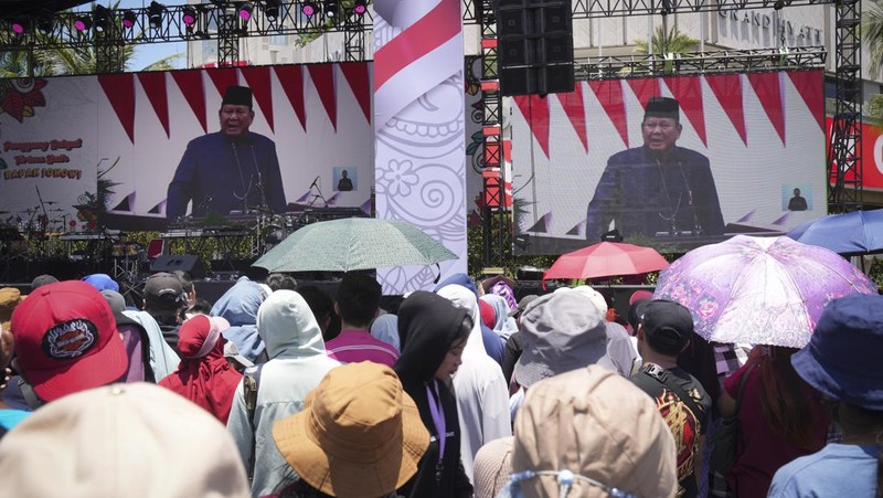 Public watch from a giant screen of Newly-inaugurated Indonesian President Prabowo Subianto speech in Jakarta, Indonesia, Sunday, Oct. 20, 2024. (AP Photo/Dita Alangkara)