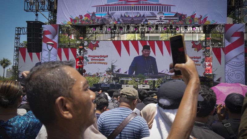 Public watch from a giant screen of Newly-inaugurated Indonesian President Prabowo Subianto speech in Jakarta, Indonesia, Sunday, Oct. 20, 2024. (AP Photo/Dita Alangkara)