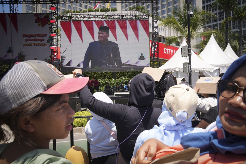 Public watch from a giant screen of Newly-inaugurated Indonesian President Prabowo Subianto speech in Jakarta, Indonesia, Sunday, Oct. 20, 2024. (AP Photo/Dita Alangkara)