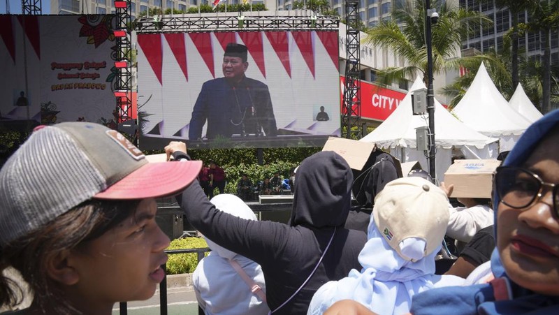 Public watch from a giant screen of Newly-inaugurated Indonesian President Prabowo Subianto speech in Jakarta, Indonesia, Sunday, Oct. 20, 2024. (AP Photo/Dita Alangkara)