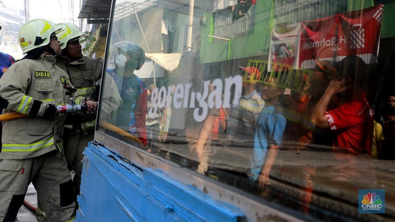 Petugas kebakaran melakukan pendinginan di lokasi Kebakaran di kawasan Mampang Prapatan, Jakarta Selatan, Minggu(20/10/2024) siang. (CNBC Indonesia/Muhammad Sabki)