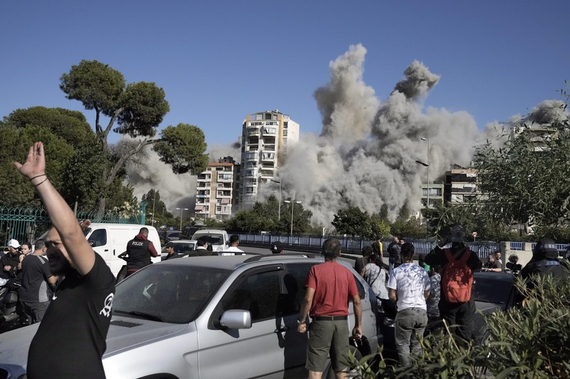 Orang-orang menyaksikan bangunan runtuh setelah terkena serangan udara Israel di Ghobeiry, Beirut, Lebanon, Selasa, 22 Oktober 2024. Orang-orang menyaksikan bangunan runtuh setelah terkena serangan udara Israel di Ghobeiry, Beirut, Lebanon, Selasa, 22 Oktober 2024. (AP Photo/Bilal Hussein)