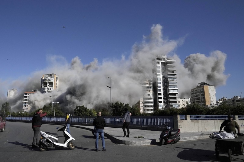 Orang-orang menyaksikan bangunan runtuh setelah terkena serangan udara Israel di Ghobeiry, Beirut, Lebanon, Selasa, 22 Oktober 2024. Orang-orang menyaksikan bangunan runtuh setelah terkena serangan udara Israel di Ghobeiry, Beirut, Lebanon, Selasa, 22 Oktober 2024. (AP Photo/Bilal Hussein)
