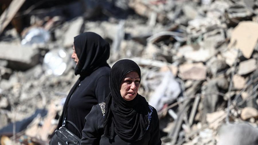 Para perempuan berdiri di lokasi serangan Israel di dekat Rumah Sakit Universitas Rafik Hariri, di tengah permusuhan yang sedang berlangsung antara Hizbullah dan pasukan Israel, di Beirut, Lebanon, 22 Oktober 2024. (REUTERS/Yara Nardi)