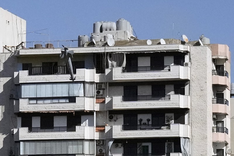 Orang-orang menyaksikan bangunan runtuh setelah terkena serangan udara Israel di Ghobeiry, Beirut, Lebanon, Selasa, 22 Oktober 2024. (AP Photo/Bilal Hussein)