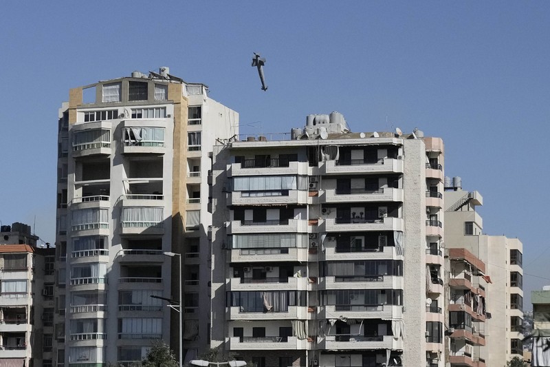 Orang-orang menyaksikan bangunan runtuh setelah terkena serangan udara Israel di Ghobeiry, Beirut, Lebanon, Selasa, 22 Oktober 2024. (AP Photo/Bilal Hussein)