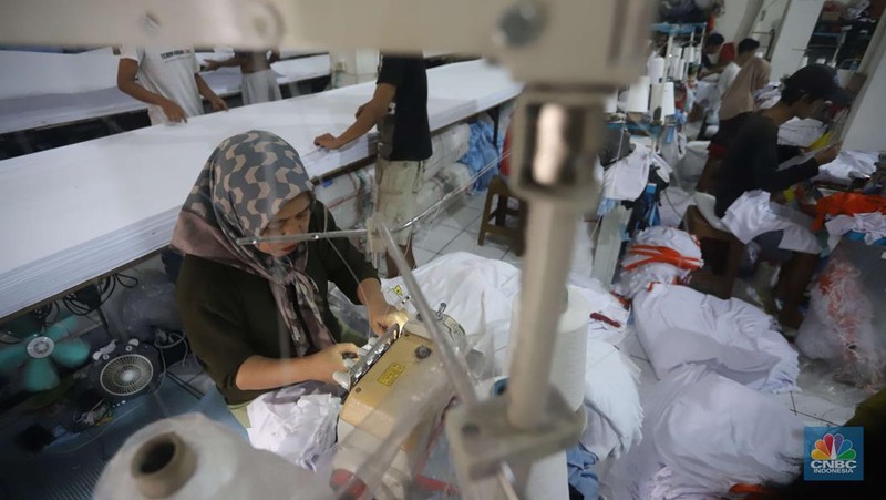 Sejumlah pekerja menyelesaikan kaos pesanan di konveksi Sinergi Adv di kawasan Serengseng Sawah, Jakarta, Rabu (23/10/2024). (CNBC Indonesia/Muhammad Sabki)