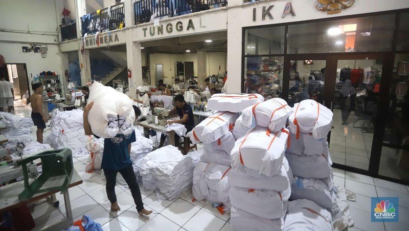 Sejumlah pekerja menyelesaikan kaos pesanan di konveksi Sinergi Adv di kawasan Serengseng Sawah, Jakarta, Rabu (23/10/2024). (CNBC Indonesia/Muhammad Sabki)