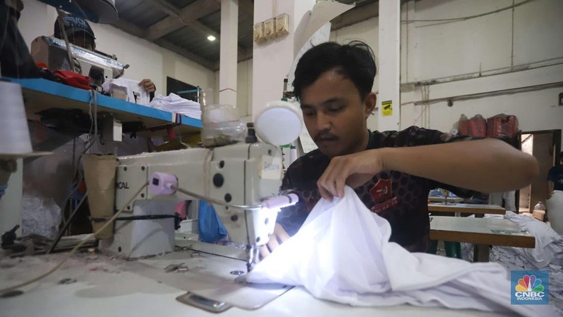 Sejumlah pekerja menyelesaikan kaos pesanan di konveksi Sinergi Adv di kawasan Serengseng Sawah, Jakarta, Rabu (23/10/2024). (CNBC Indonesia/Muhammad Sabki)